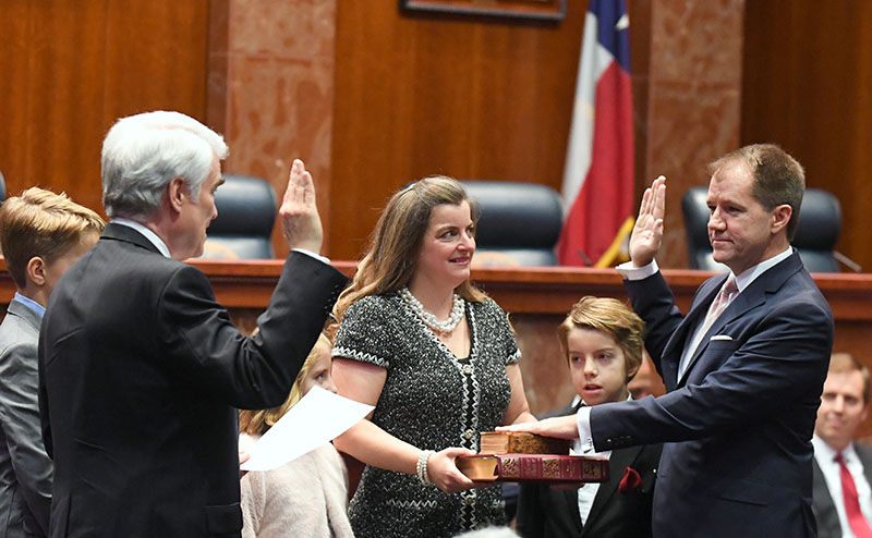 Judge Willett takes his oath from Chief Justice Hecht as Tiffany, his wife, and children look on.